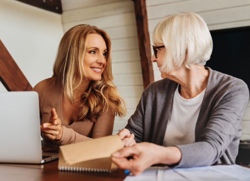 Portrait of businesswoman consulting with retired woman at home